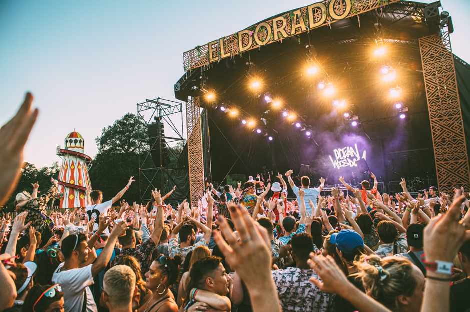 Crowd dancing with arms in the air in front of stage at El Dorado Festival